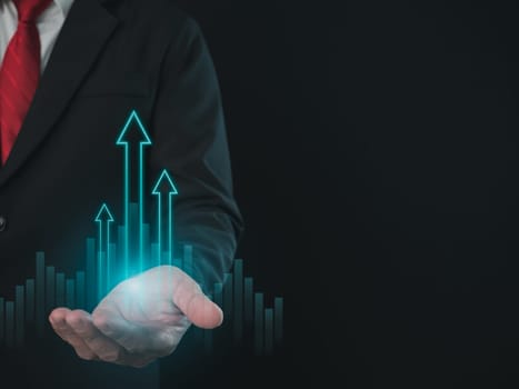 Stock trading. Finance. Investing. Growing business. Businessman in suit showing finger pointing to arrow tip on gray background.