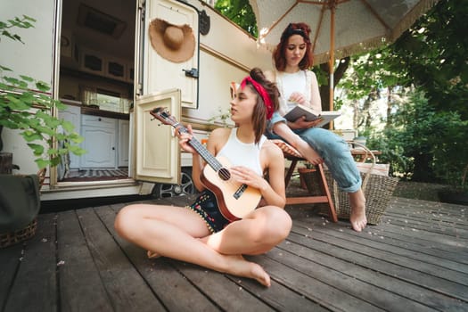 Happy hippie friends are having a good time together in camper trailer. Holiday, vacation, trip concept. High quality photo