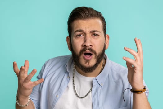 Oh my God, Wow. Excited amazed winner man surprise looking at camera with big eyes, shocked by sudden victory. Sincere confused shocked handsome lebanese guy isolated alone on blue studio background