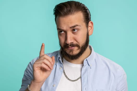 Eureka. Inspired young lebanese man pointing finger up with open mouth, having good idea, plan, startup, showing inspiration motivation gesture, problem solution. Arabian guy on beige background