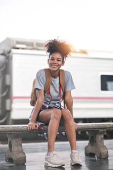 Young Asian African woman traveler with backpack in the railway train station, traveler girl walking stand sit waiting take a picture on railway platform train station. High quality photo..