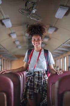 Young asian travel by train sticking her head out of the train. Happy smiling woman female girl looks out from train window travelling by train