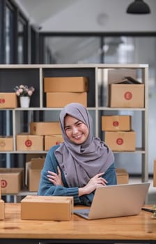 Muslim asian woman freelancer entrepreneur, Smile for sales success after checking order from online shopping store in a laptop at home office, Concept of merchant business online and eCommerce..