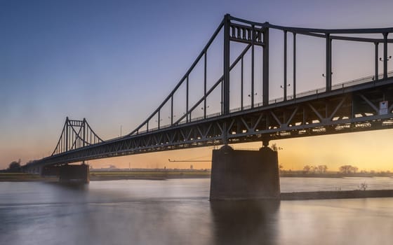 Old bridge crossing the Rhine river during sunset, Krefeld, North Rhine Westphalia, Germany