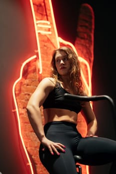 young beautiful woman on elliptical orbitrek machine in fitness gym.