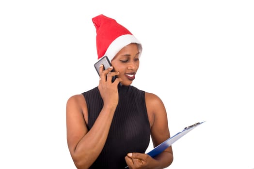 Smiling woman wearing christmas hat, talking on the phone ready to write goals on a blank list for new year.