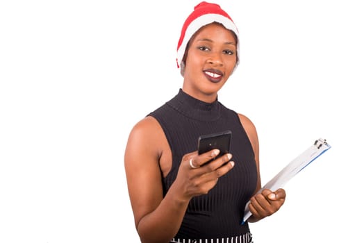 Smiling woman wearing christmas hat, talking on the phone ready to write goals on a blank list for new year.