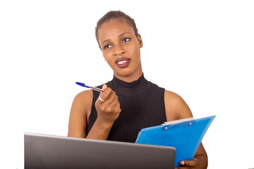 Young confident secretary or office manager sitting in front of his office and writing his business plan in front of his laptop