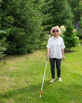 Elderly blind woman walking in the park