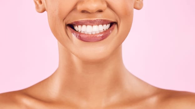 Woman, teeth and smile, beauty and dental with shine on lips, oral health and veneers isolated on pink background. Female model, orthodontics and wellness, cosmetics and closeup of mouth in studio.