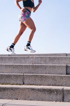 vertical cropped photo of the legs of an unrecognizable african american woman running outdoors, concept of sports and active lifestyle, copy space for text