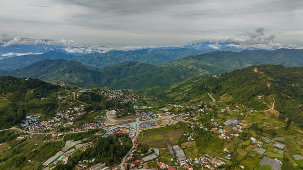 Aerial drone of city is located in the mountains among farmland at the foot of Mount Kinabalu. Kundasang, Ranau. Borneo, Sabah, Malaysia.