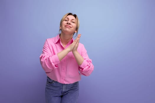 young beautiful european blond office worker woman dressed in a pink shirt and jeans begging.