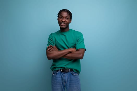 charming brunette model stylish african guy in a t-shirt on a blue background.