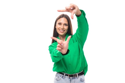 pretty young caucasian brunette lady with makeup dressed in a green shirt and jeans posing on a white background with copy space.