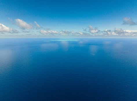 Surface of blue ocean and blue sky with cloud, aerial view. Water cloud horizon background.