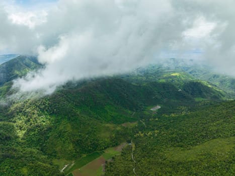 Aerial drone of mountains and hills with green forest and clouds. Negros, Philippines