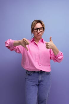 young doubtful blond woman with ponytail and glasses dressed in a trendy pink shirt for the office.