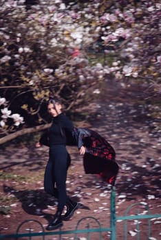 Beautiful dramatic young woman wearing kimono with cherry blossoms, sakura view. High quality photo