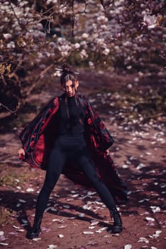 Beautiful dramatic young woman wearing black kimono with cherry blossoms, sakura view. High quality photo