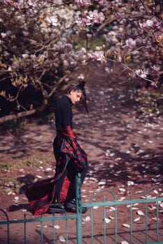 Beautiful dramatic young woman wearing kimono with cherry blossoms, sakura view. High quality photo