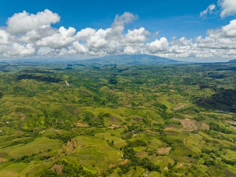 Farmland on a background of blue sky and clouds in a mountainous area. Negros, Philippines
