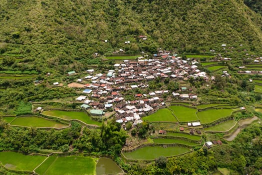 Village among rice terraces and fields in the mountains view from above. Philippines, Luzon.