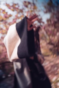 Beautiful dramatic young woman hiding her face wearing kimono with cherry blossoms, sakura view. High quality photo