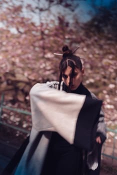 Beautiful dramatic young woman wearing kimono with cherry blossoms, sakura view. High quality photo