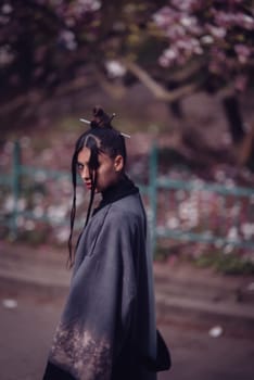 Beautiful dramatic young woman wearing kimono with cherry blossoms, sakura view. High quality photo