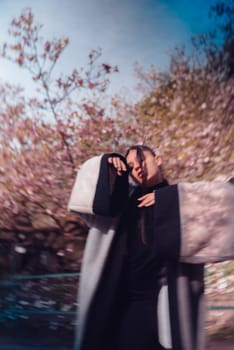 Beautiful dramatic young woman wearing kimono with cherry blossoms, sakura view. High quality photo