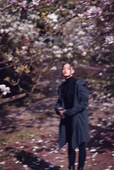 Beautiful dramatic young woman wearing kimono with cherry blossoms, sakura view. High quality photo