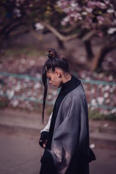 Beautiful dramatic young woman wearing kimono with cherry blossoms, sakura view. High quality photo