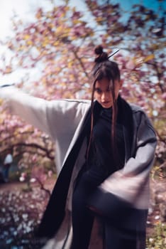 Beautiful dramatic young woman wearing kimono with cherry blossoms, sakura view. High quality photo