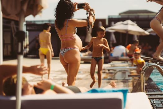 back view of pregnant woman in bikini on the beach. High quality photo