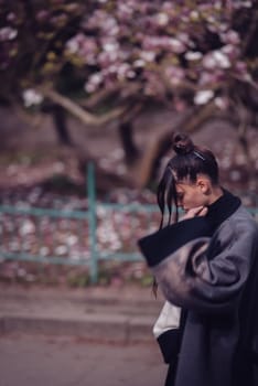 Beautiful dramatic young woman wearing kimono with cherry blossoms, sakura view. High quality photo
