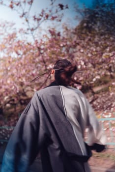 Beautiful dramatic young woman wearing kimono with cherry blossoms, sakura view. High quality photo