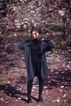 Beautiful dramatic young woman wearing kimono with cherry blossoms, sakura view. High quality photo