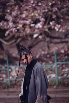 Beautiful dramatic young woman wearing kimono with cherry blossoms, sakura view. High quality photo