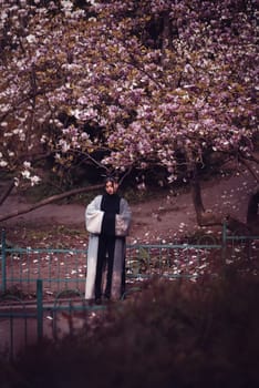 Beautiful dramatic young woman wearing kimono with cherry blossoms, sakura view. High quality photo
