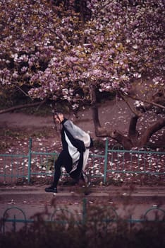 Beautiful dramatic young woman wearing kimono with cherry blossoms, sakura view. High quality photo
