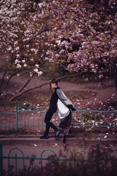 Beautiful dramatic young woman wearing kimono with cherry blossoms, sakura view. High quality photo