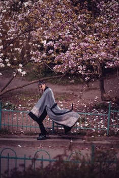 Beautiful dramatic young woman wearing kimono with cherry blossoms, sakura view. High quality photo