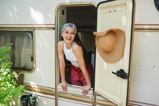 Happy hippie girl are having a good time in a camper trailer. Holiday, vacation, trip concept.High quality photo