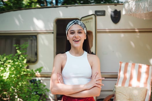 Happy hippie girl are having a good time in a camper trailer. Holiday, vacation, trip concept.High quality photo