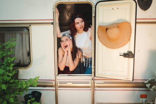 Happy hippie friends are having a good time together in a camper trailer. Holiday, vacation, trip concept. High quality photo