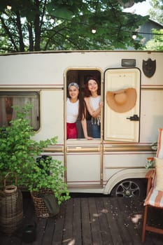 Happy hippie friends are having a good time together in a camper trailer. Holiday, vacation, trip concept. High quality photo