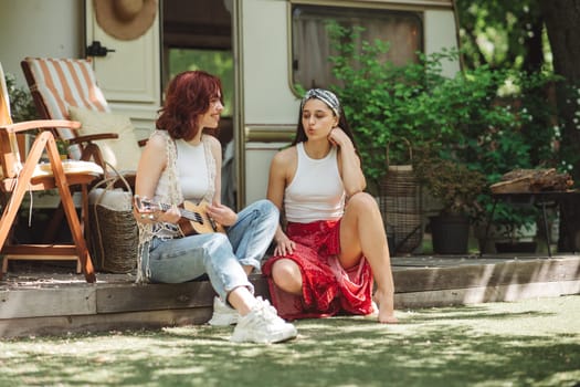 Happy hippie friends are having a good time together in camper trailer. Holiday, vacation, trip concept. High quality photo