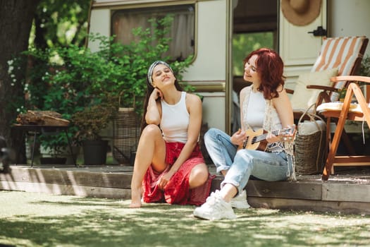 Happy hippie friends are having a good time together in camper trailer. Holiday, vacation, trip concept. High quality photo