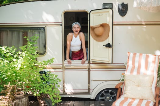 Happy hippie girl are having a good time in a camper trailer. Holiday, vacation, trip concept.High quality photo